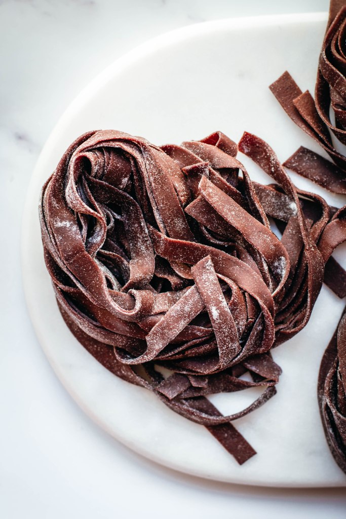 Fresh pasta is a labour of love and great pasta needs practice: these homemade cocoa tagliatelle are a wonderful way to step-up your pasta game pairing a very basic shape with cocoa powder and its characteristic flavours and colour. Delicious when served with melted cheese and spices, this fresh pasta with cocoa will definitely surprise you with its special taste.