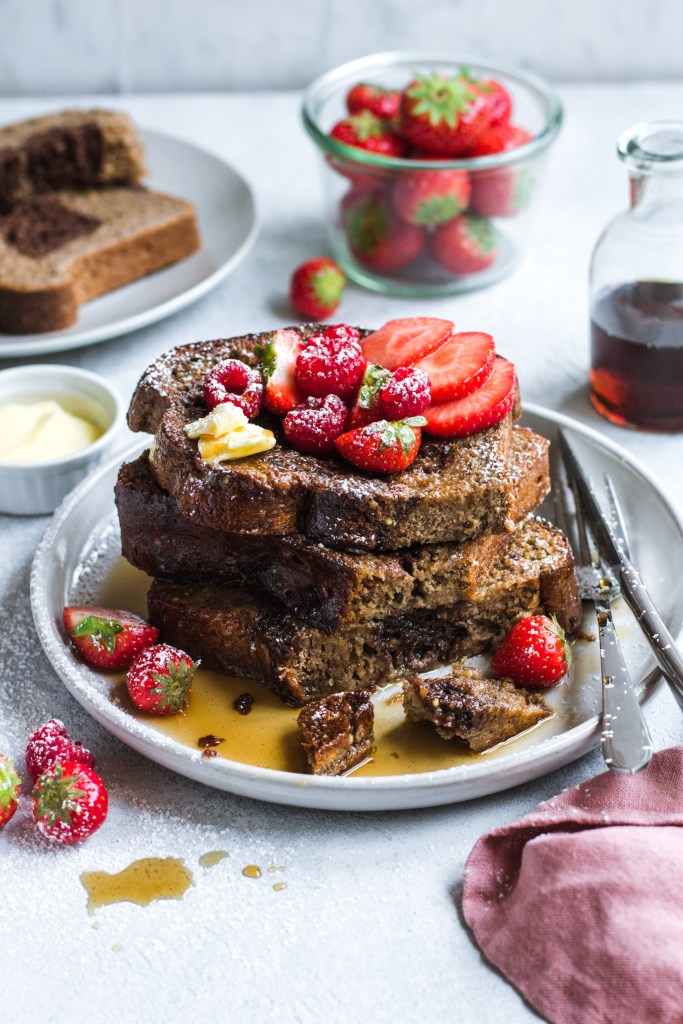 French toast with fresh strawberries and raspberries, butter and maple syrup. Recipe development, food photography and styling by Chiara Gianelli.