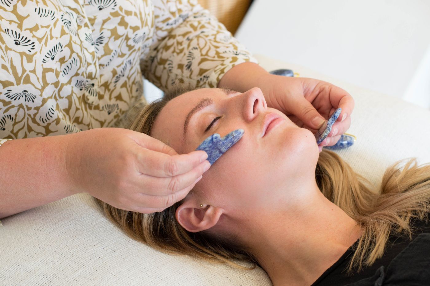 Woman receiving a facial treatment with gua sha. Brand photography by Chiara Gianelli.