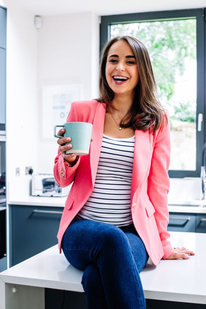 Brand photography of a woman wearing a pink blazer holding a cup of tea