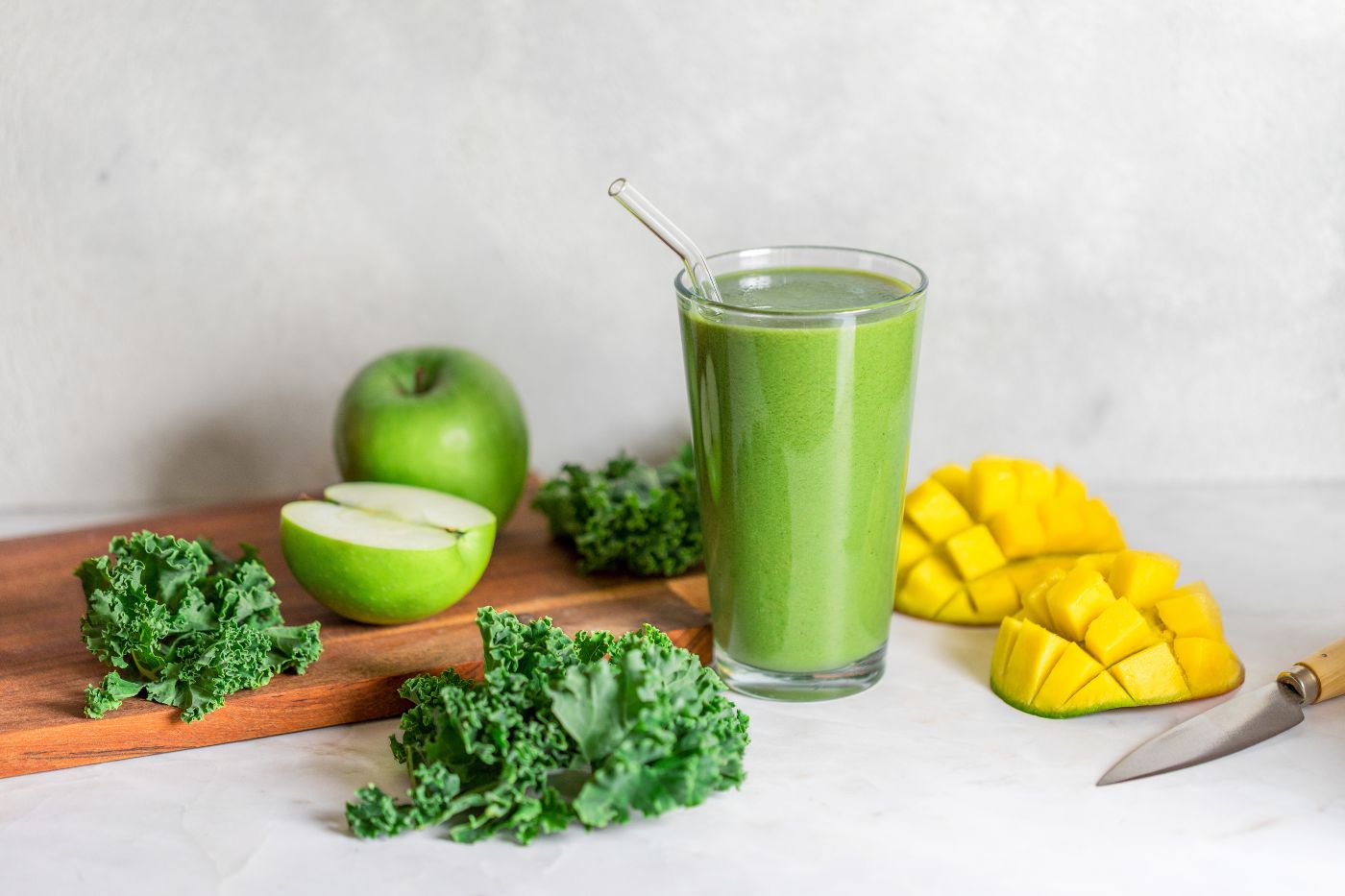 Food photography of a green smoothie with fresh mango, apple, and kale