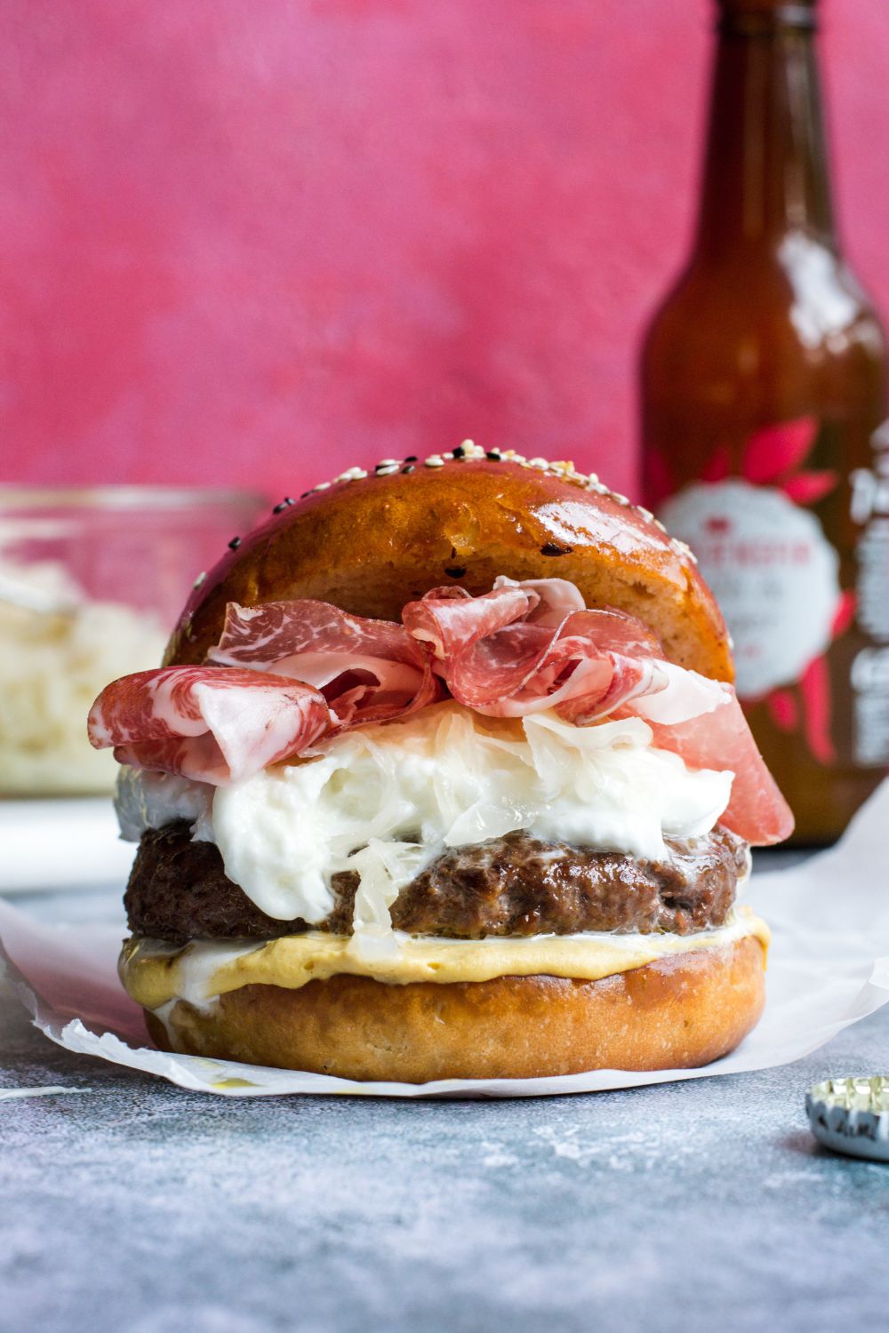 Food photo on pink background. Burger with mustard, sauerkraut, coppa, buffalo mozzarella. Styled by food photographer Chiara Gianelli in Dublin