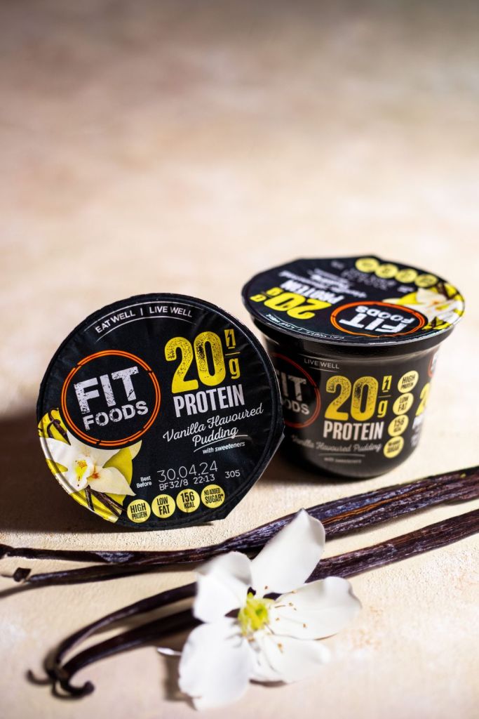 Product photo of protein puddings with vanilla and a white flower on a cream background. Dublin food photographer Chiara Gianelli