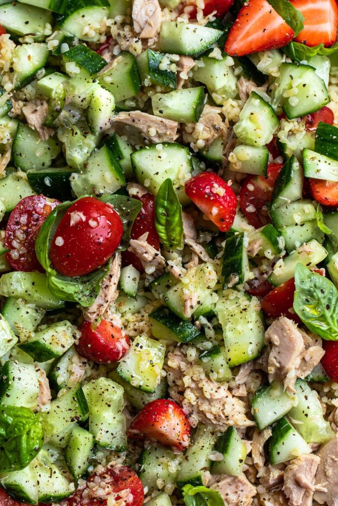 Close up of a salad with tomatoes, tuna, strawberries, cucumber, basil and bulgur. Food photography by Chiara Gianelli