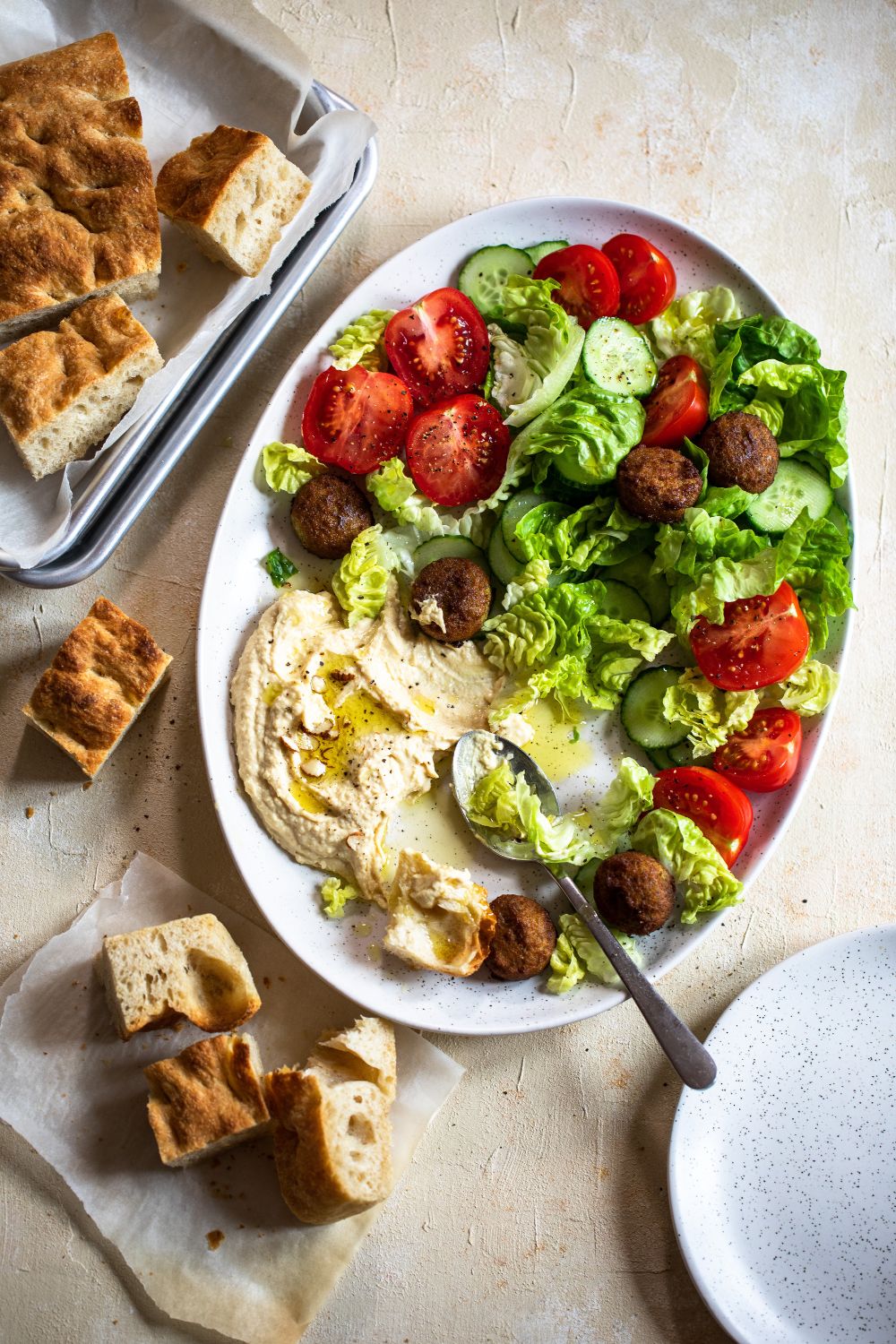 Salad with lettuce, fresh tomatoes, falafel and whipped feta served with focaccia styled by Dublin food photographer Chiara Gianelli