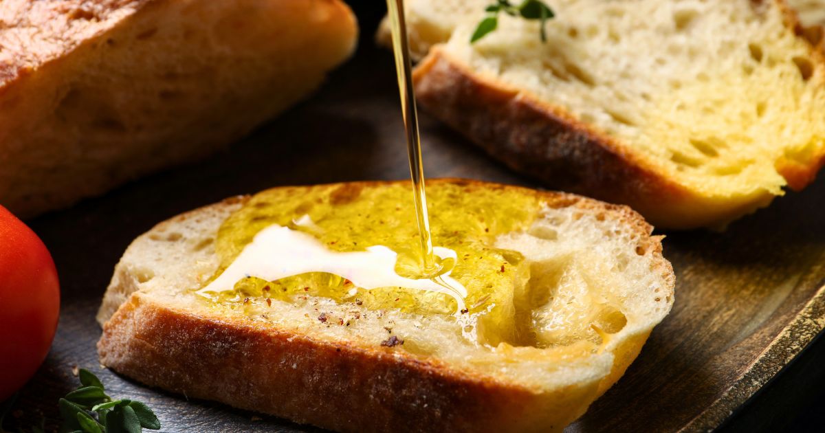 Decorative image of a close up of olive oil being poured on a slide of bread