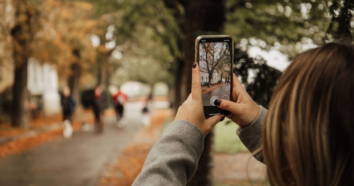 Decorative photo of a person holding a phone and taking a photo